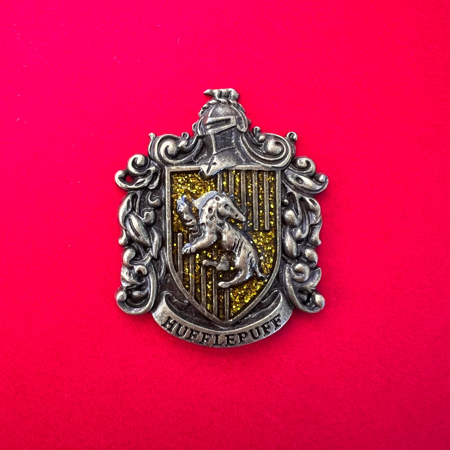 Pin metálico de la insignia de la casa Hufflepuff, del universo de Harry Potter