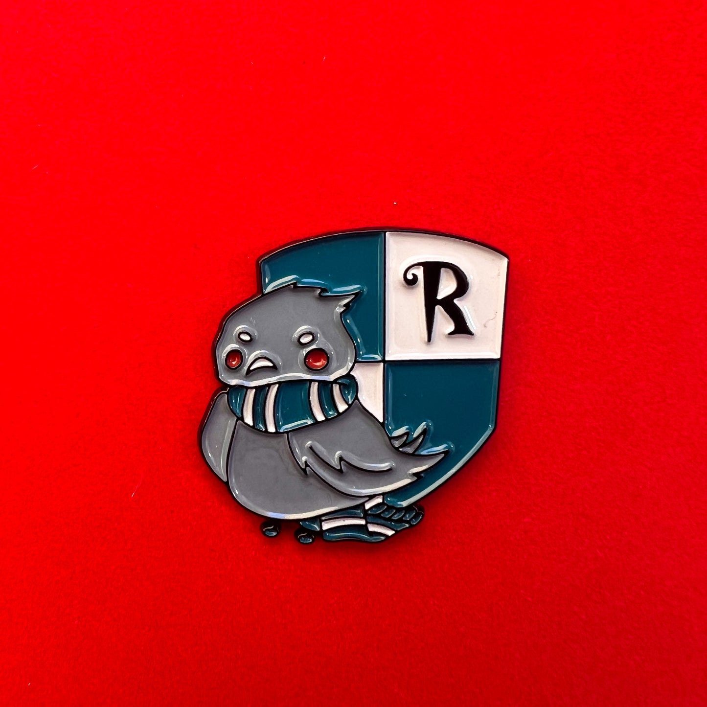 Pin de Ravenclaw con un águila adorable sobre el escudo de la casa, en tonos azules y bronce.