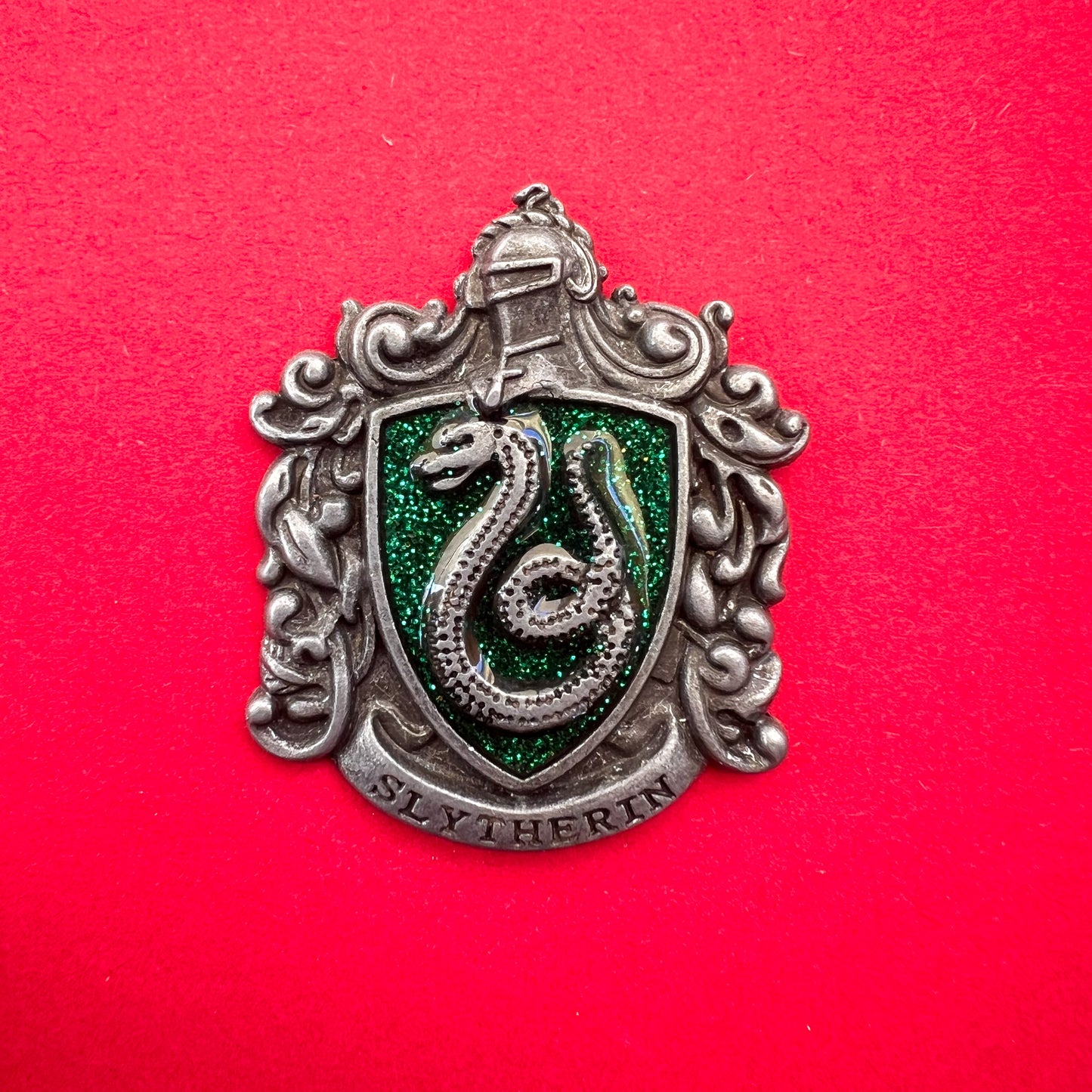 Pin metálico de la insignia de la casa Slytherin, del universo de Harry Potter