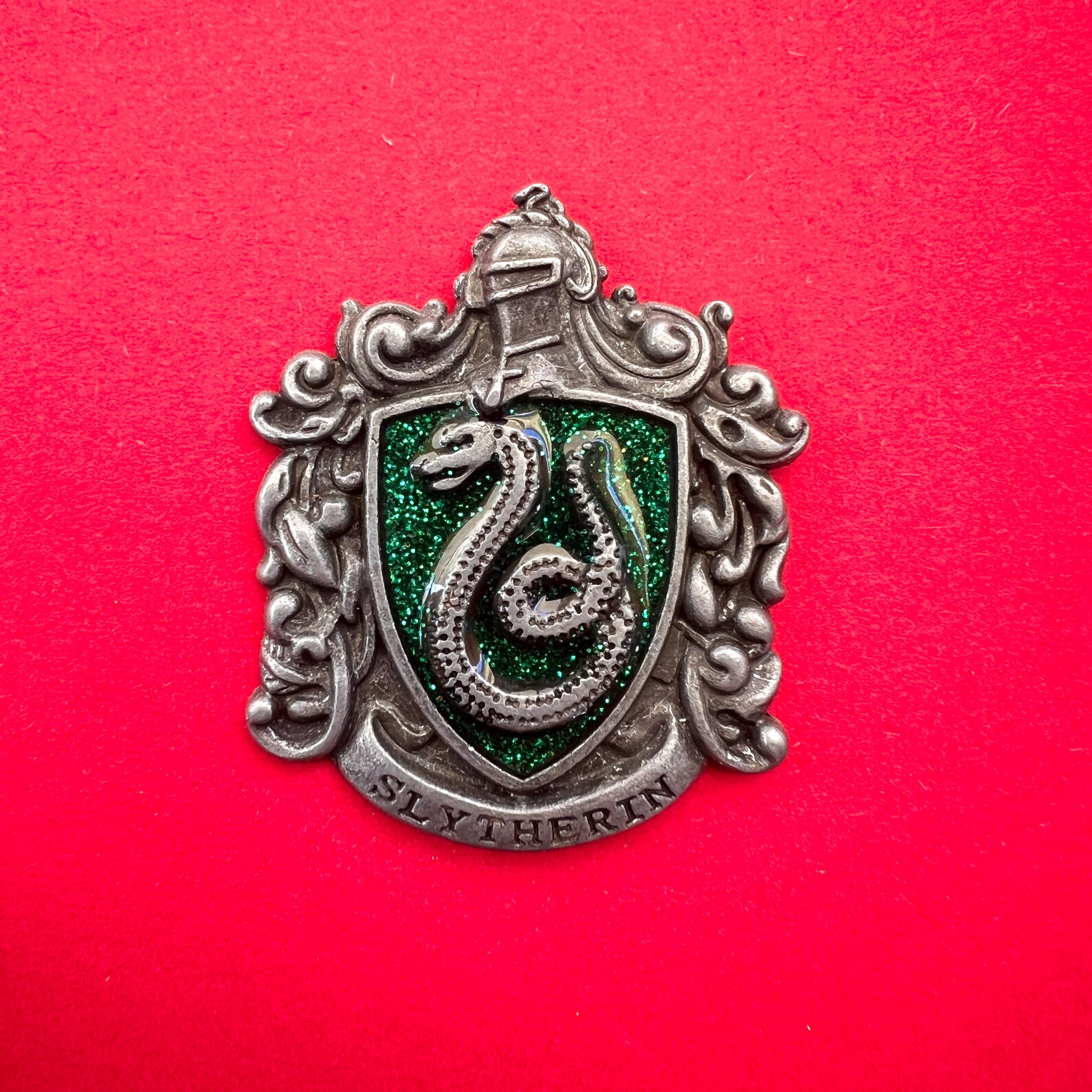 Pin metálico de la insignia de la casa Slytherin, del universo de Harry Potter