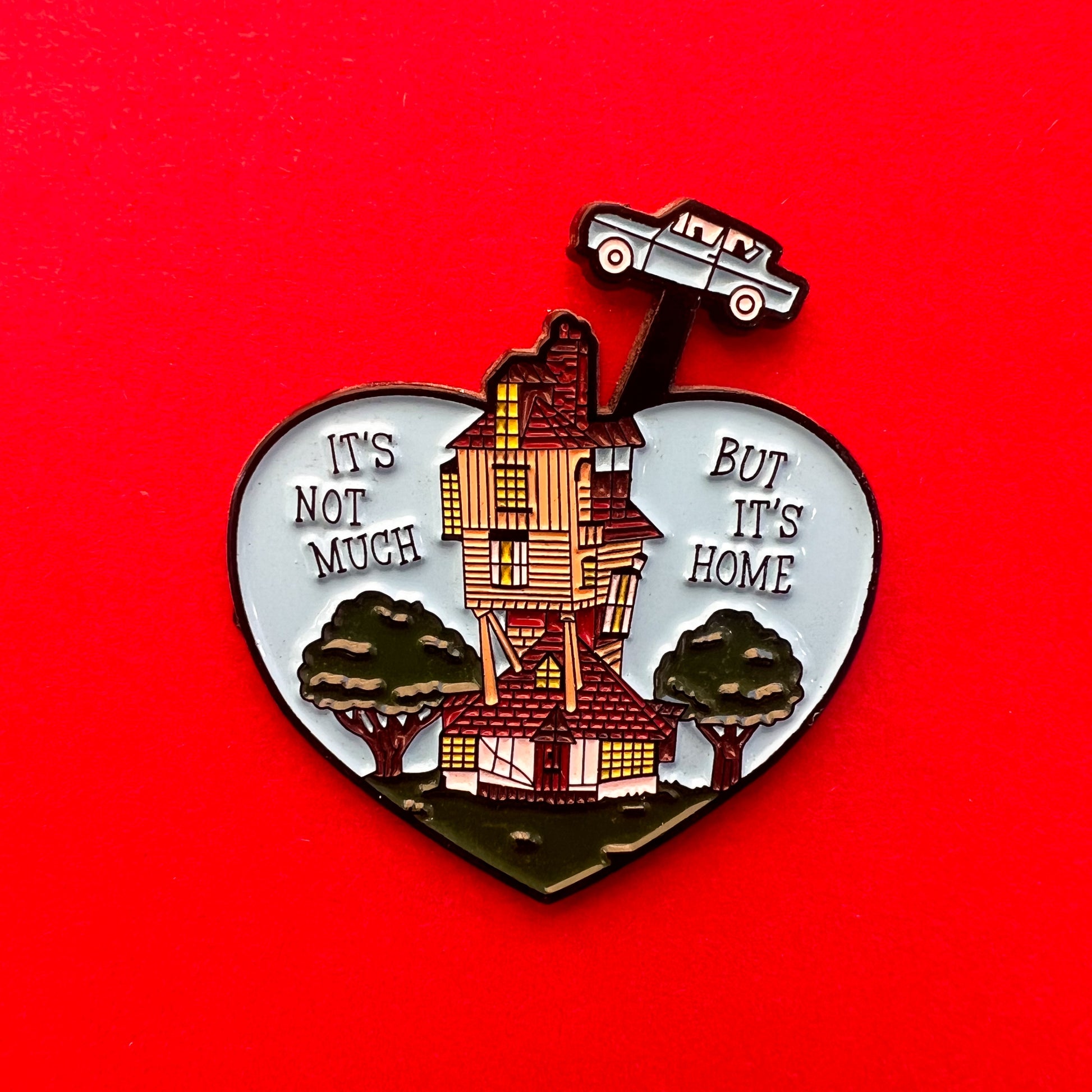 Pin de la casa de la familia Weasley, "La madriguera", con las palabras "it's not much, but it's home"