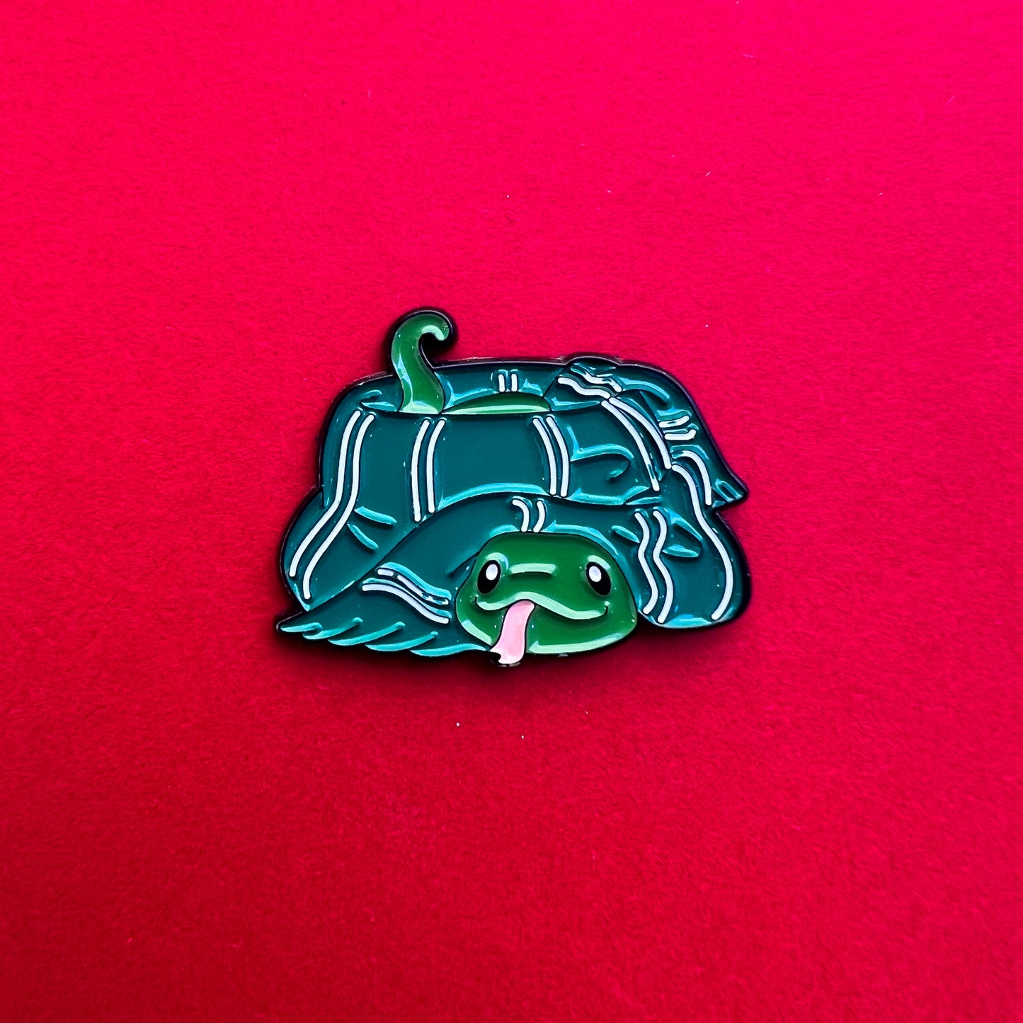 Pin de Slytherin: serpiente adorable con bufanda verde y plateada. ¡Ideal para astutos y ambiciosos!