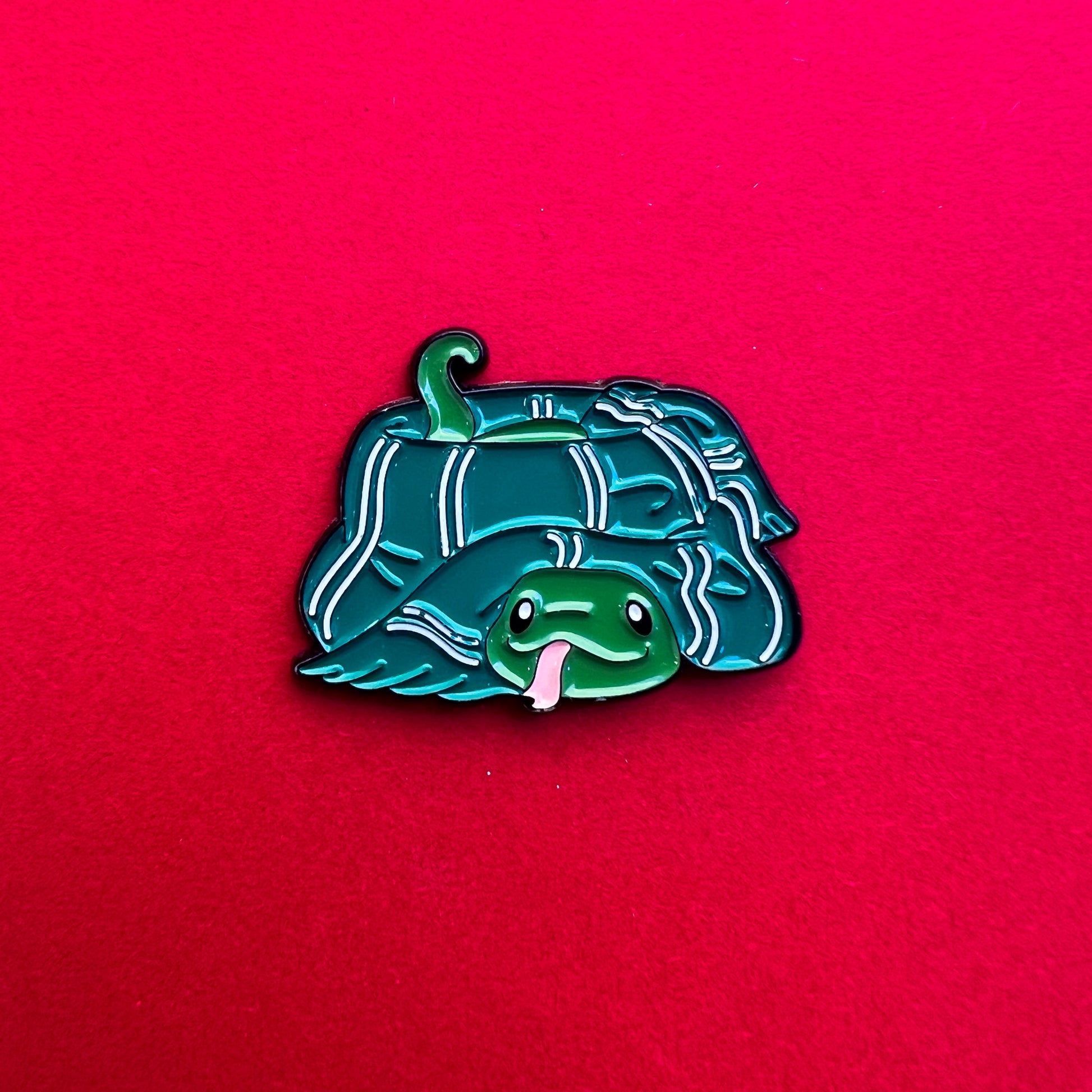 Pin de Slytherin: serpiente adorable con bufanda verde y plateada. ¡Ideal para astutos y ambiciosos!