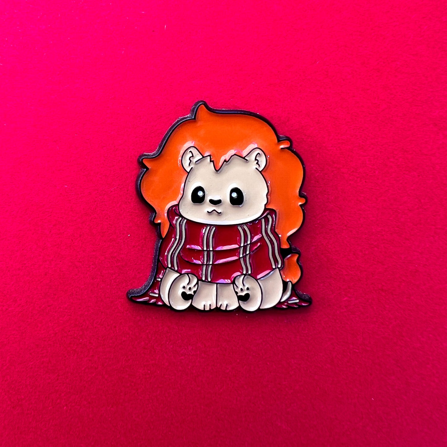 Pin de Gryffindor: león tierno con bufanda roja y dorada. ¡Perfecto para fans valientes y nobles!