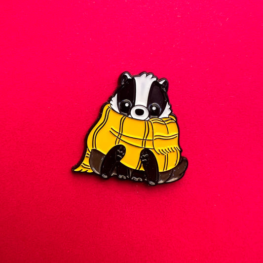 Pin de Hufflepuff: tejón tierno con bufanda amarilla y negra. ¡Ideal para leales y trabajadores!